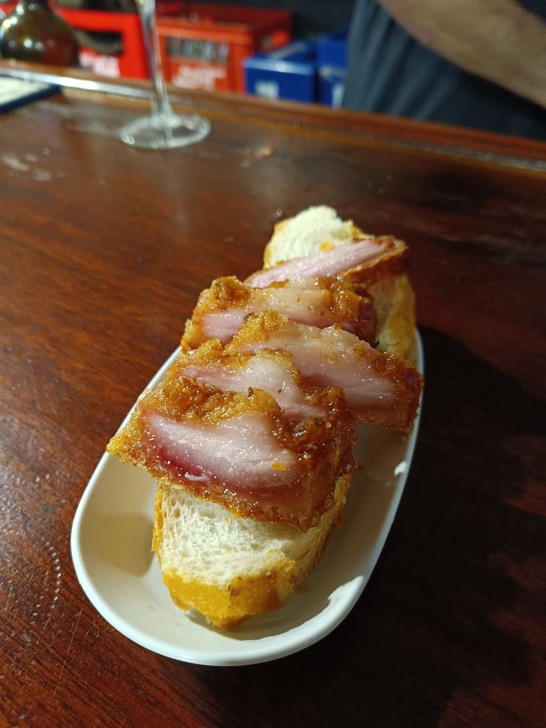 Torreznos crujientes sobre rebanadas de pan tostado
